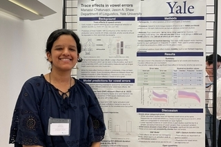 Manasvi Chaturvedi smiles in front of her poster