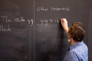 Patrick writing Cherokee on a chalkboard