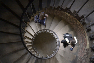 Looking down on a spiral staircase with students walking up