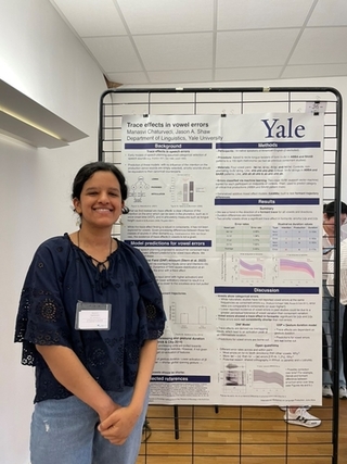 Manasvi Chaturvedi smiles in front of her poster